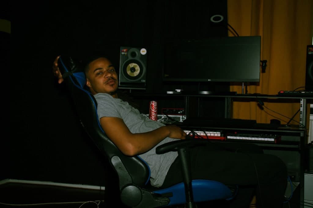 Tyrone achter de studiodesk bij R.E.R. met monitors en productiemateriaal